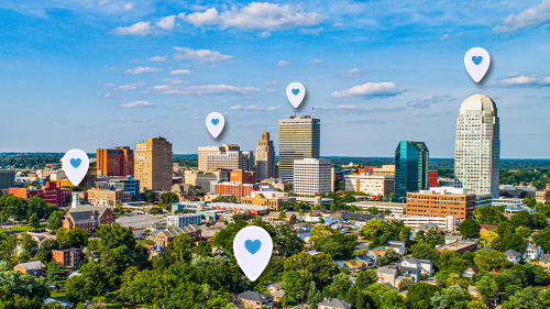 Winston-Salem skyline with purple location graphics in various places with a blue heart.
