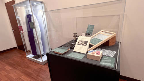 A display from The Magic of the Fourth Ward exhibit with resident artifacts, including a washboard and religious vestments.