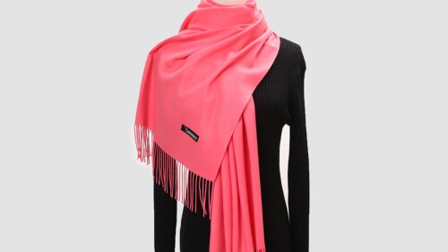 A mannequin wearing a pink fringed cashmere shawl. 