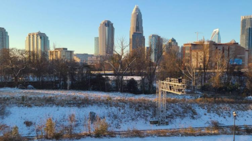 A dusting of snow covers the roads and hills adjacent to the Uptown Charlotte skyline.