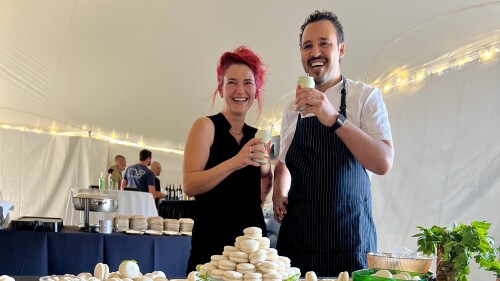 Pastry chef Youssef Boudarine stands behind booth of macarons with Ariel 