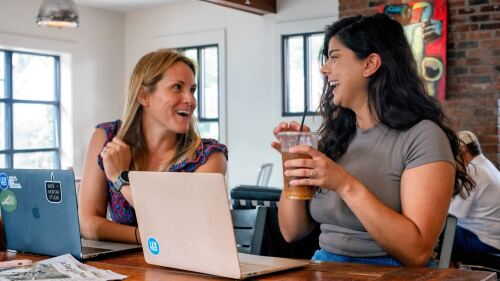 City Editors Molly and Aayat chat over their laptops. 