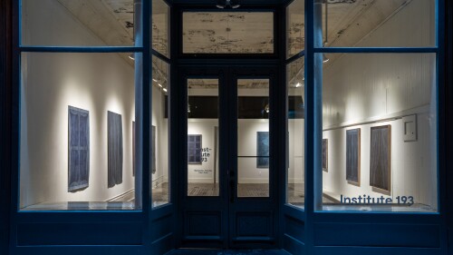 A windowed storefront with the name "Institute 193" painted on the window. It is a gallery, with several paintings hanging on the wall.