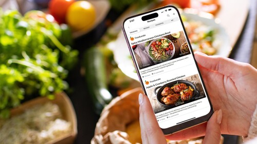 A woman's hands holding a phone open to the Fooducate app.