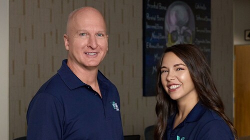 dr. gregory taylor stands poses with a co-worker