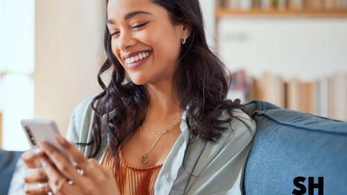 A woman smiles while on her cell phone. 