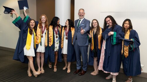 Dr. Larry Miller posing with Greenville Tech grads at graduation. 