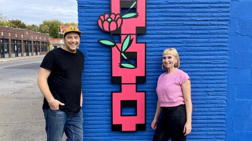 Owners of Guide & Anchor stand in front of signage on their building