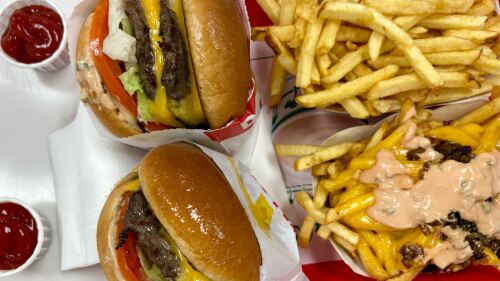 A photo of two burgers and fry platters from In-N-Out Burger.