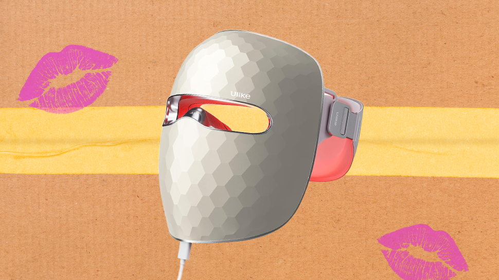 A red light therapy mask in front of a cardboard box.
