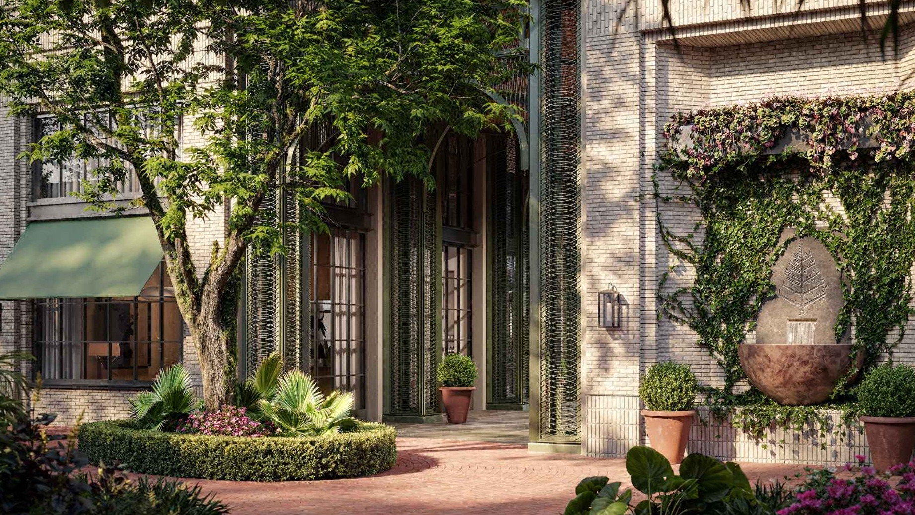 Elegant garden courtyard with lush landscaping, a large tree surrounded by manicured shrubs, and a wall-mounted water fountain covered in ivy. The building features tall arched windows, green shutters, and soft green awnings over ground-level windows.